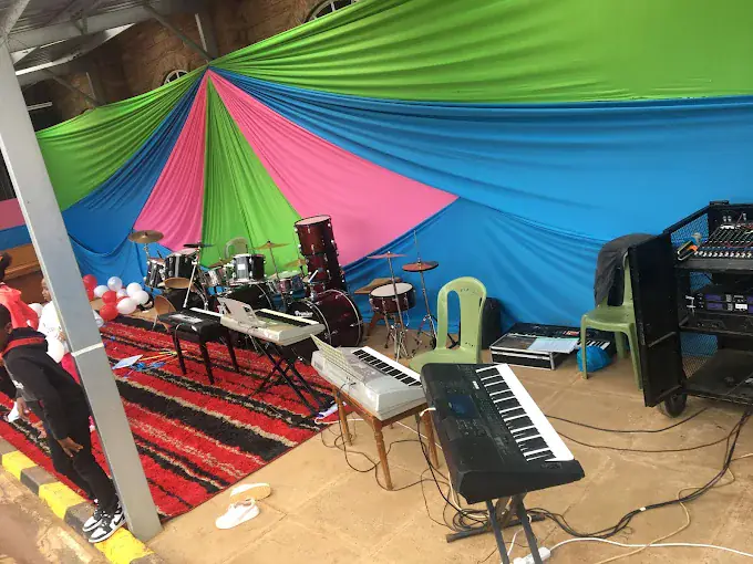 Drums, keyboards and PA set up on a draped stage for an event — equipment hire and setup by Concerto Music Place