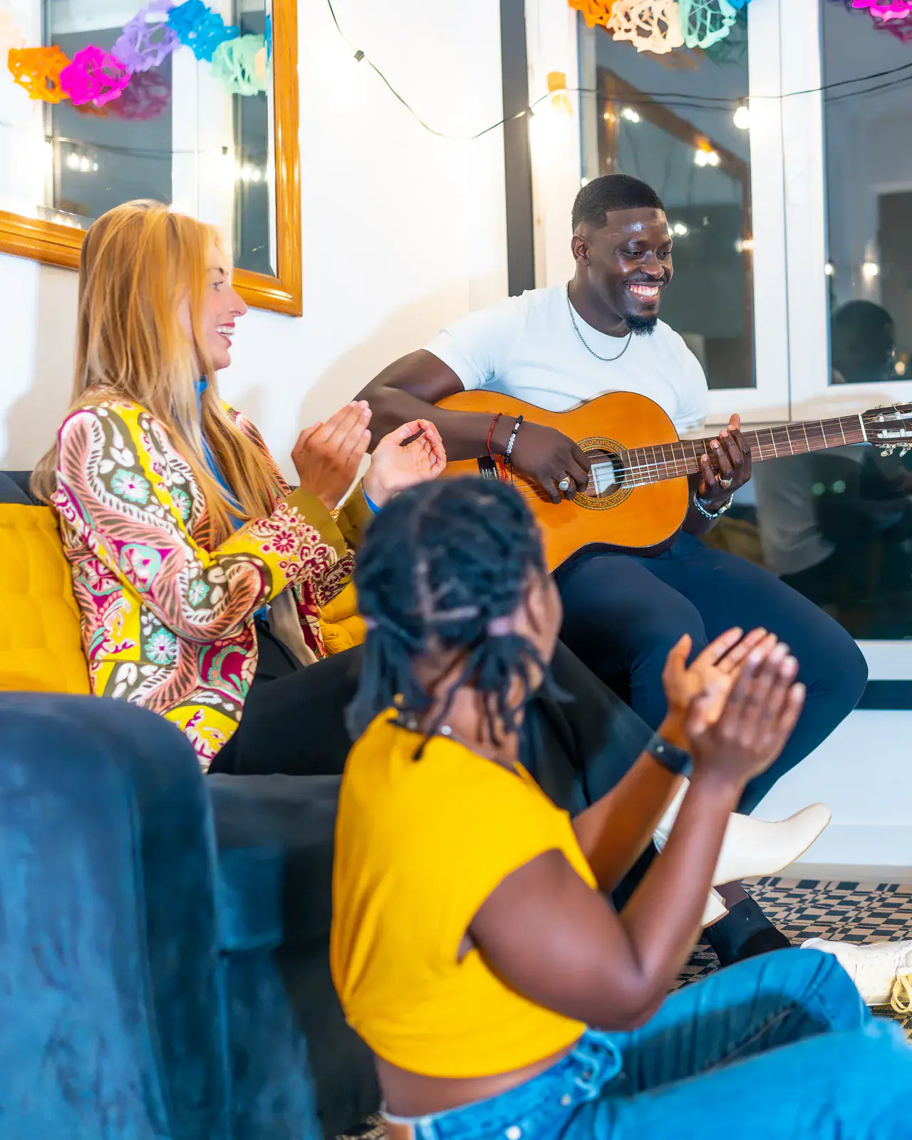 Family and friends enjoying guitar music at home — family music lessons at Concerto Music Place