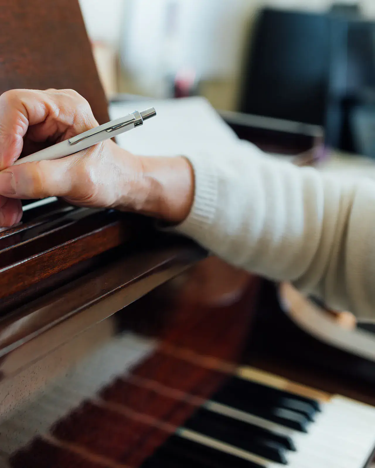 Hand writing musical notes on a piano — music education insights from Concerto Music Place