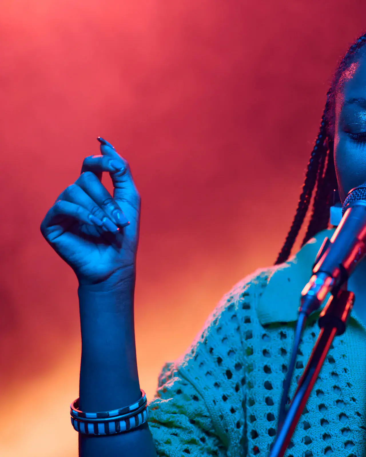 Performer singing into a microphone under dynamic lighting — Kenya Music Festival coaching by Concerto Music Place
