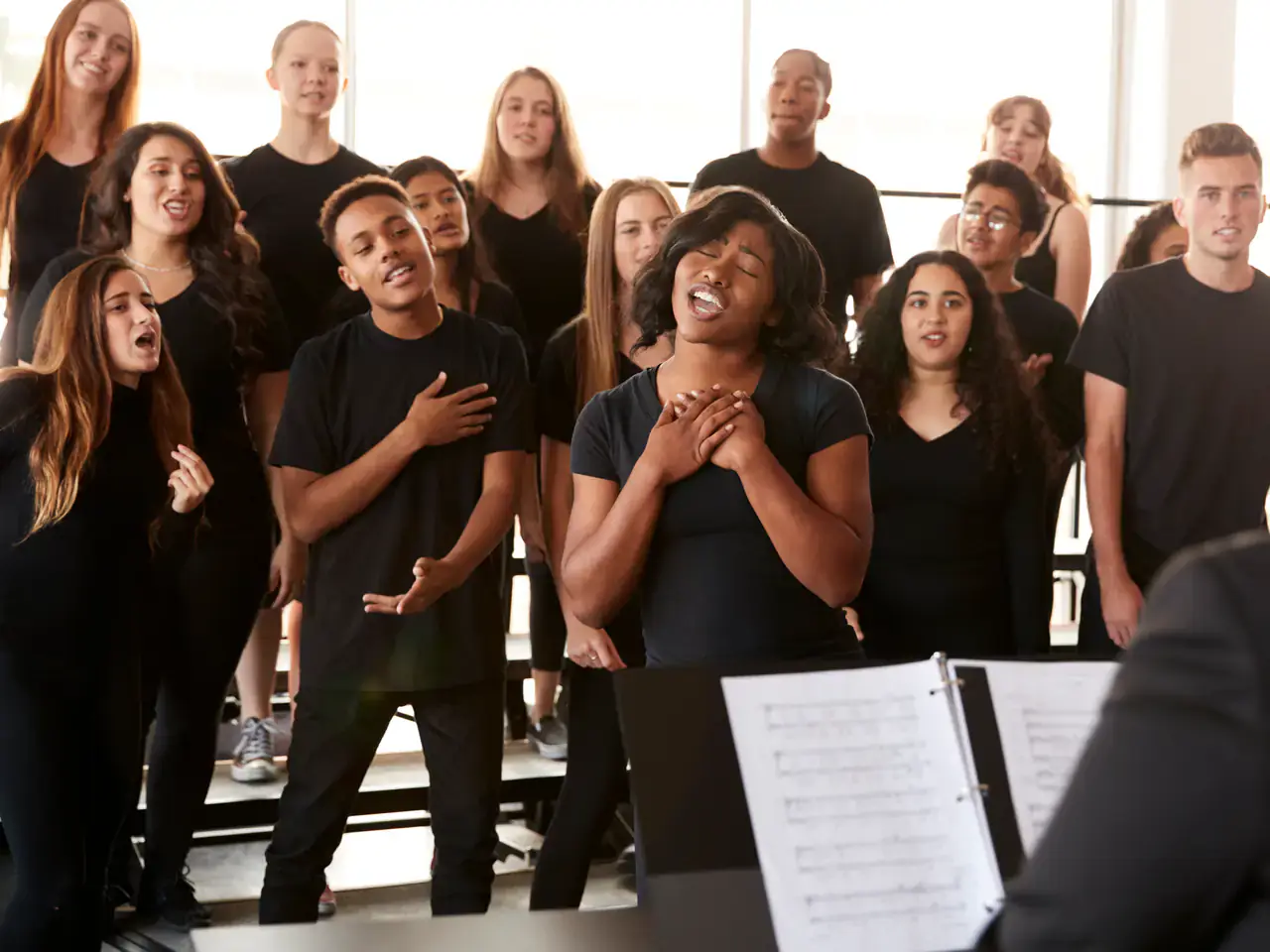 A student singing with passion in a choir, led by a director — vocal training at Concerto Music Place, Kikuyu